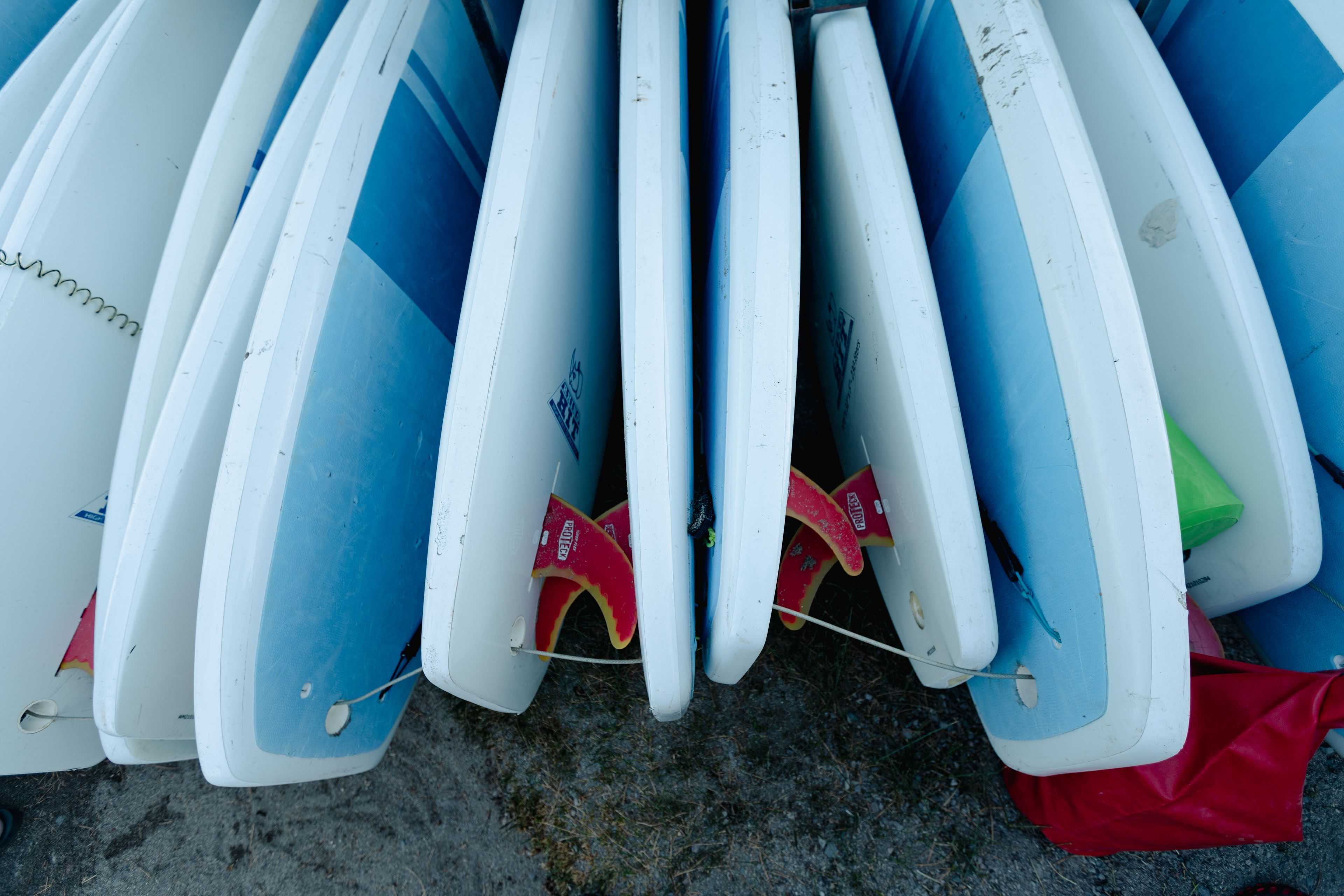 paddle boards laying on the beach